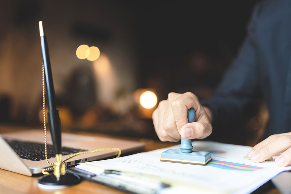 man's hand stamping a document