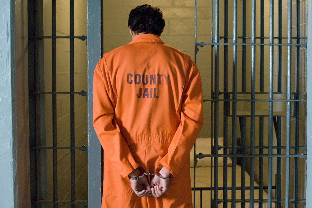 Handcuffed prisoner in jail