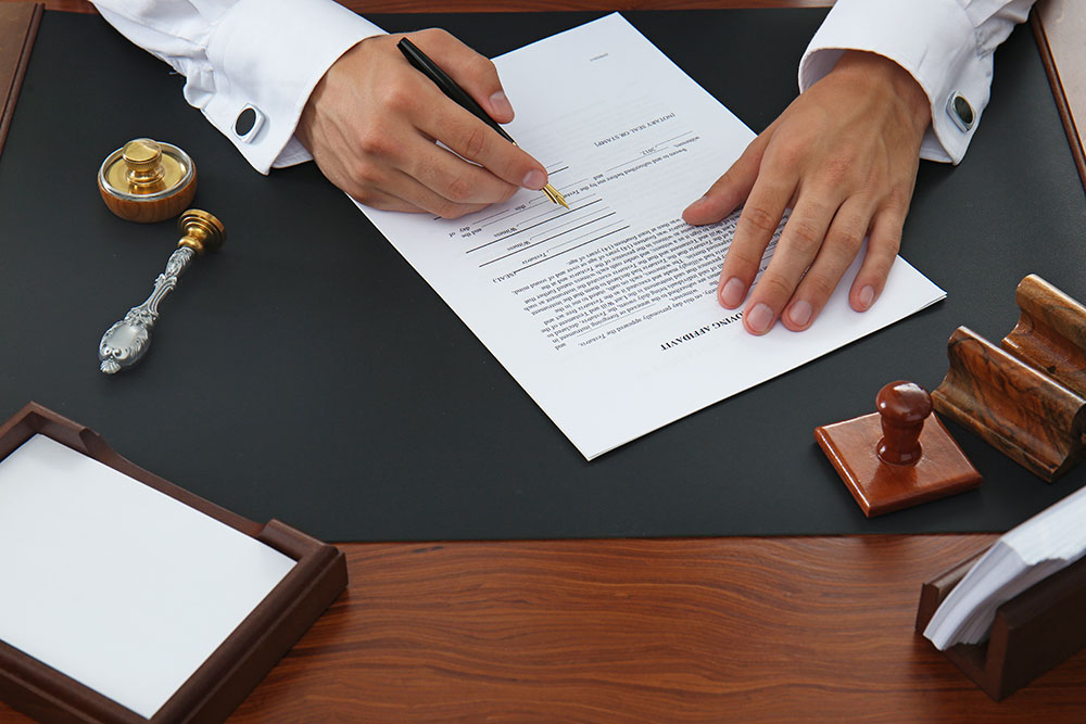Notary public signing affidavit document in office