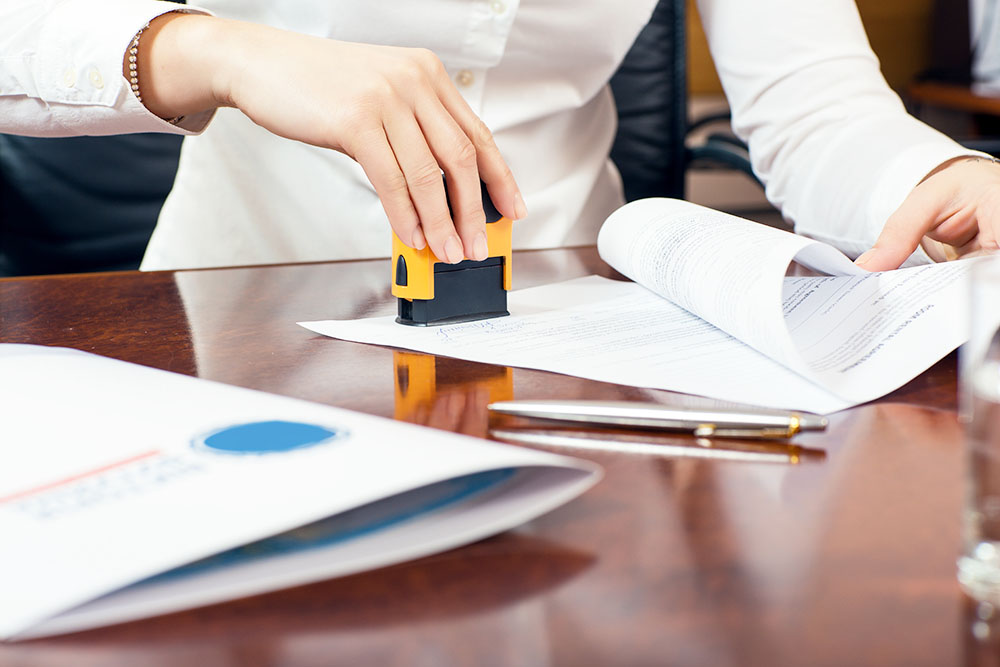 female hand stamping document, working at office