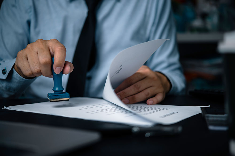 man's hand stamping and notarizing a document