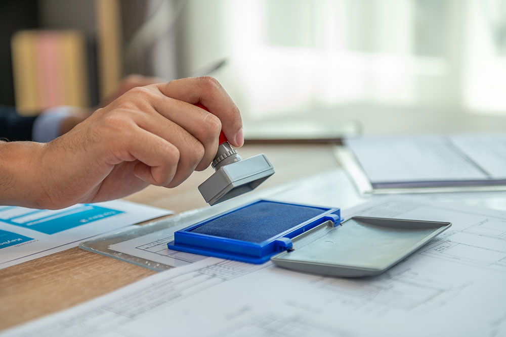 A person stamping a document with a rubber stamp.