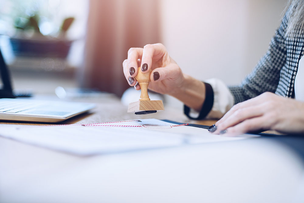 woman notary public stramping a document on her desk