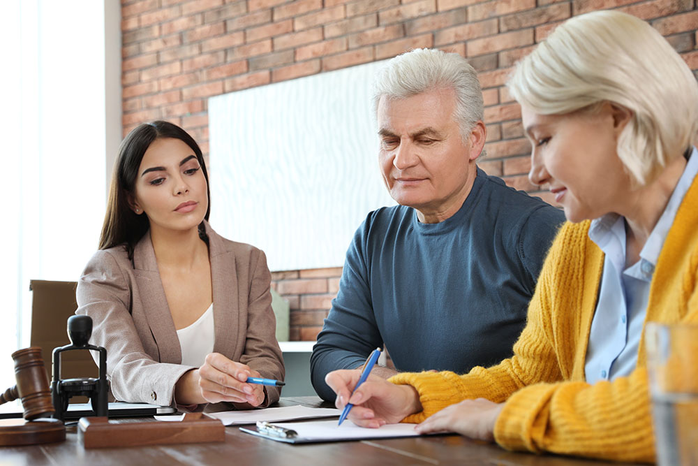 female notary working with mature couple in office