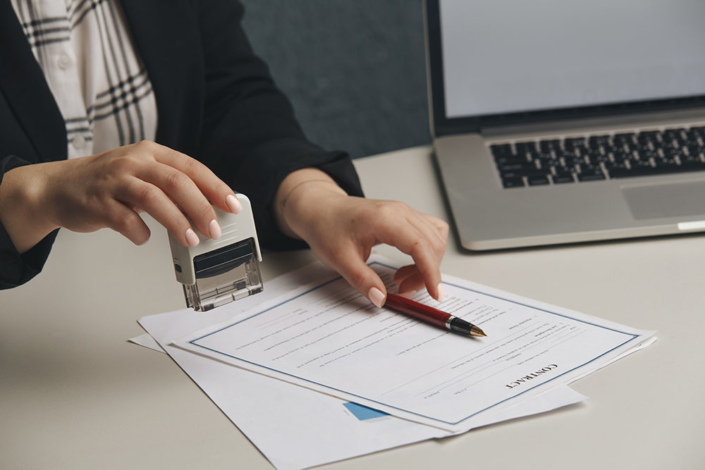 close up on woman's notary public hand stamping the document. notary public concept