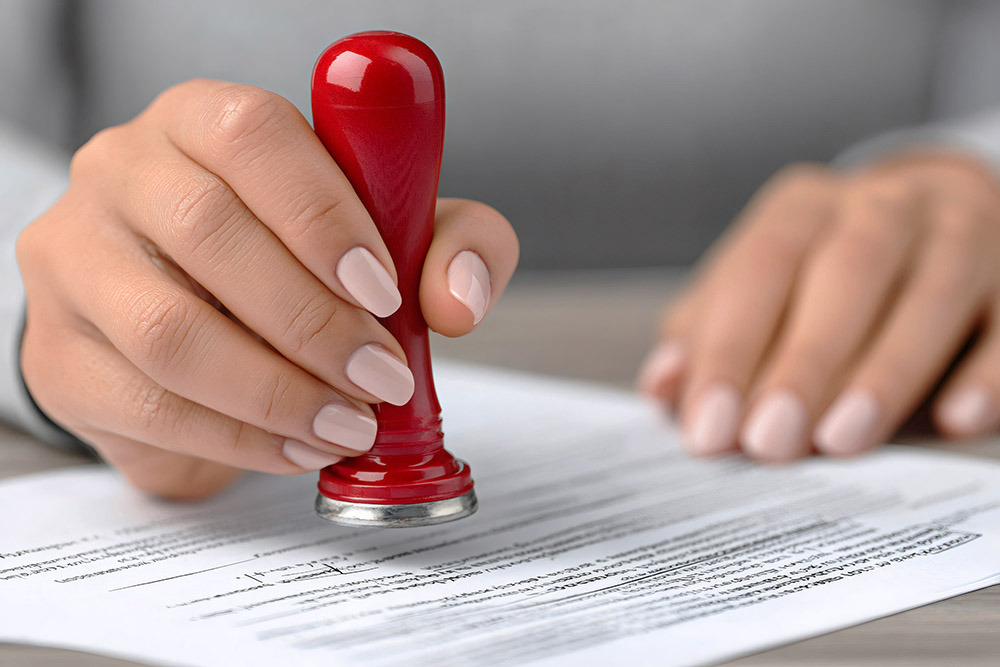 notary public applying stamp to document legalizing agreement