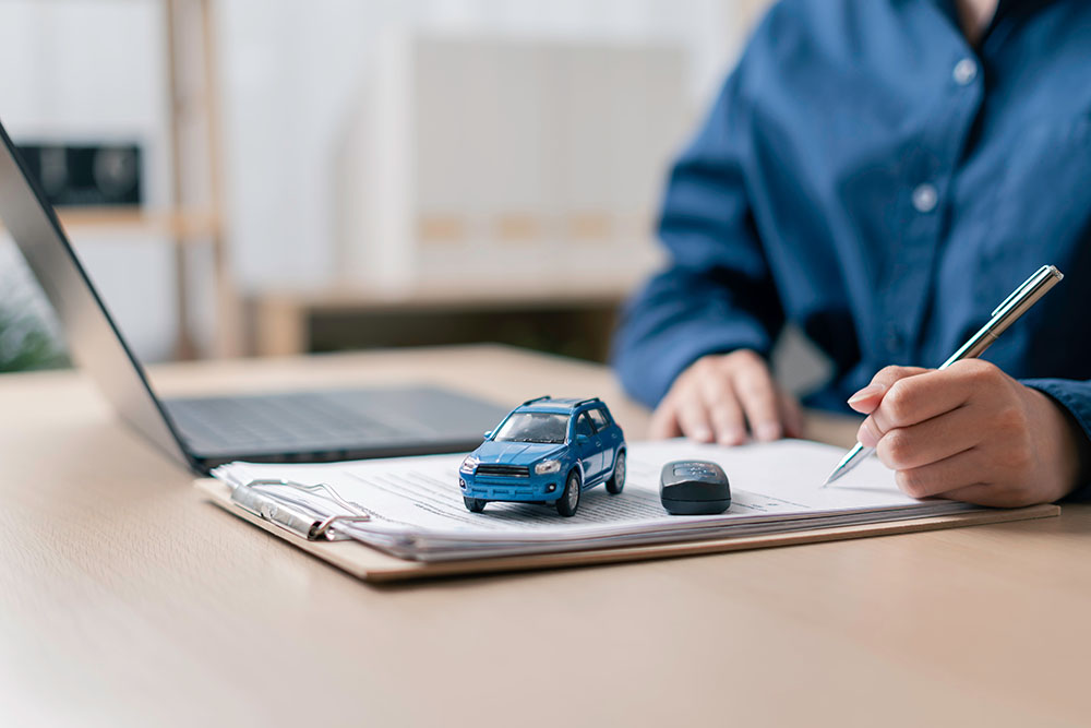 buyer signing vehicle registration papers on a clipboard