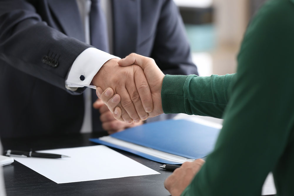 notary and client shaking hands in office