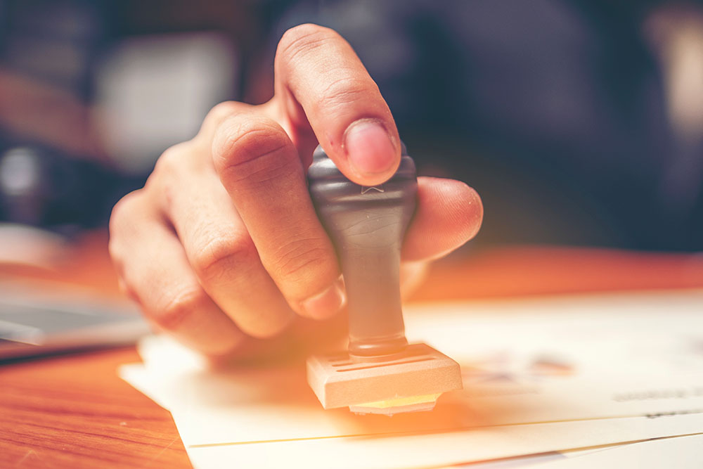 closeup of notary hand stamping a document