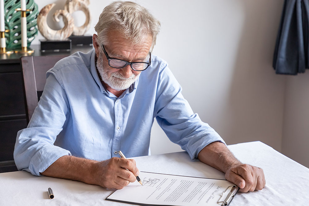 senior old man elderly examining and signing last will and testament