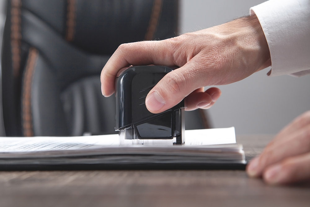 notary places his stamp on a document