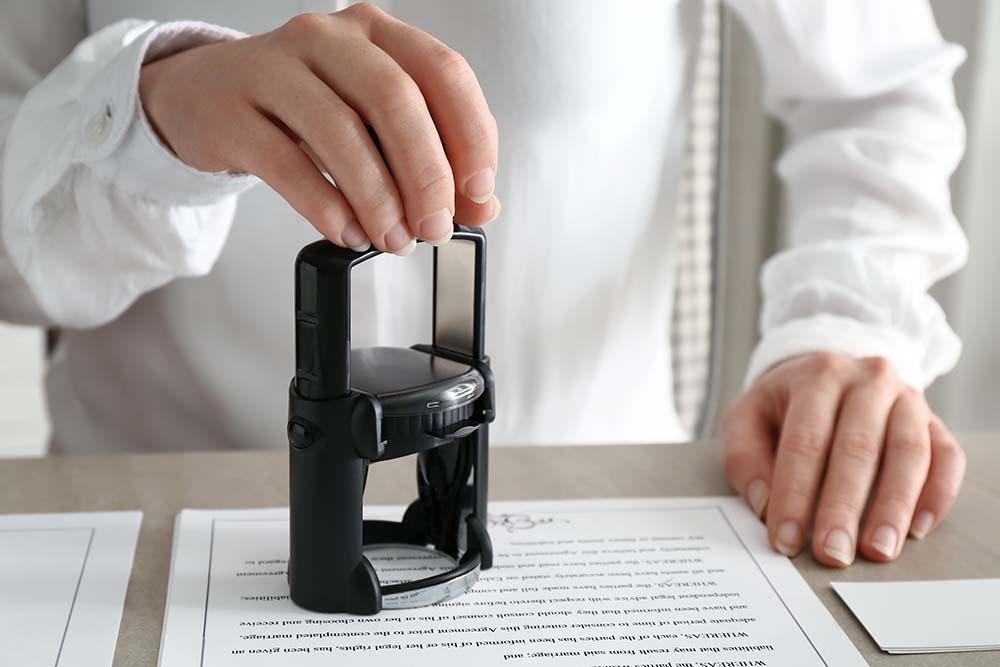 notary public stamping document in office